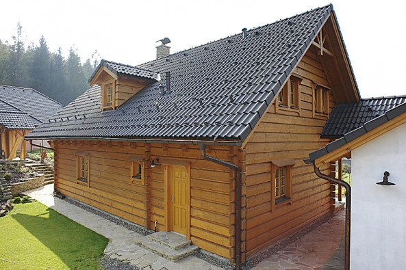 Pohled na východní fasádu. Ochranu dřeva zajišťuje impregnace na bázi mořské soli a nátěr barvou z lněného oleje. Technická místnost má samostatný výstup na zahradu.