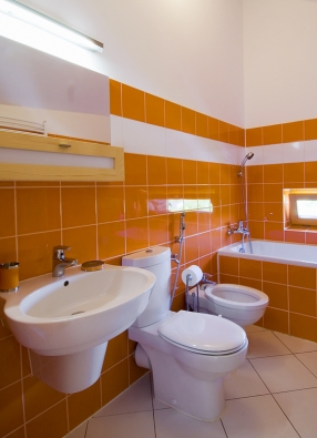 Sanitární keramiku a obklad tuzemské výroby majitel pořídil za přijatelnou cenu. Koupelna v oranžovo-bílém provedení vyznívá působivě a velmi elegantně.