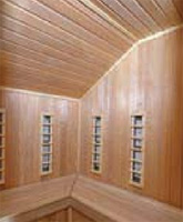 Interiér atypické, individuálně řešené infrakabiny, která je provedena ze světlého topolového dřeva a vestavěna do rohu místnosti (SAUNY SALUS, cena od 100 000 Kč).
