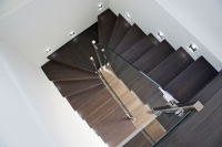 Dubové schodišťové stupně jsou mořeny do stejného odstínu jako podlaha v obývacím pokoji.