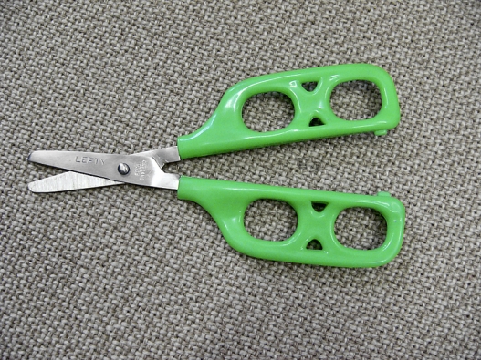 Nůžky pro dítě-leváka s otvory, které dítěti pomůžou při stříhání.