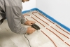 1) Instalace kabelu: Při stanovení délky a roztečí kabelu použijte již zmíněnou Příručku pro podlahové topení. Kabel připevníme k čisté podlaze pomocí tavné pistole nanesením vrstvy tavného lepidla.