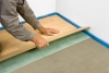 3) Položení podlahové krytiny: Na zaschlou výplňovou vrstvu položíme hrubou lepenku nebo pěnovou podložku kvůli kročejové izolaci. Na takto připravený povrch položíme plovoucí dřevěnou nebo laminátovou podlahu podle pokynů výrobce.