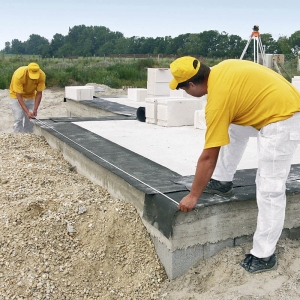 Na izolované (hydroizolace š. 500 mm) základové desce se dle projektu vyměří přesné rozměry půdorysu a poloha budoucích obvodových stěn.