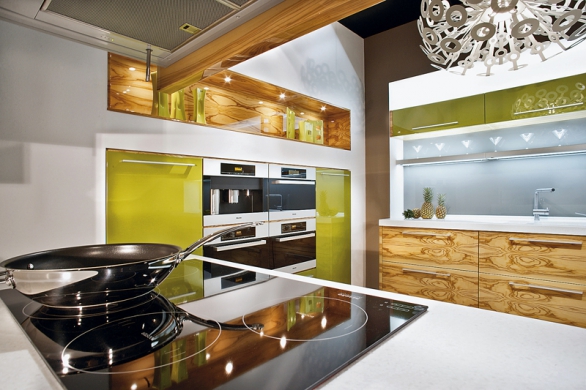 Dřevo a dřevěné doplňky harmonizují v kuchyňském prostoru prvky ohně a vody (kuchyně KORYNA vybavená spotřebiči MIELE).