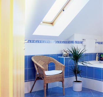Koupelna v podkroví s vkusnou kombinací bílých a modrých obkládaček.