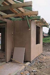 Detail dřevěné konstrukce domu s ekopanely. Stavba roste rychle.