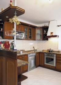 Poněkud rustikální ráz kuchyně vyvažuje úsporný design obývacího pokoje.