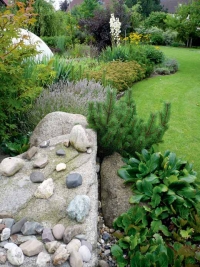 Partie z přírodních kamenů – vodní prvek v popředí umocňuje ladnou linii záhonů.