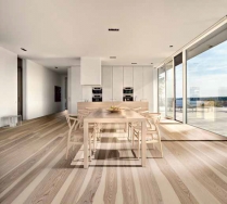 Dřevo s velmi výrazným dekorem (podlaha Kährs, typ Sand Dekor) „snese“ jen jednoduchý nábytek a tmavá či bílá okna.