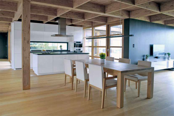 Díky proskleným plochám jsou osoby v kuchyni v kontaktu s hlavní obytnou částí i okolím domu. Architektonické řešení umožňuje vycházet do zahrady všemi směry.