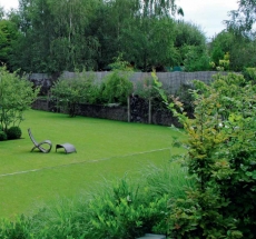 V relaxačních zahradách hotelového typu nesmí chybět kvalitní trávník. V tomto případě vytváří zelený podklad pro pečlivě střižené buxusy, které mají evokovat rozsypané kuličky na dětském hřišti. Motiv se opakuje i v jiných částech zahrady.