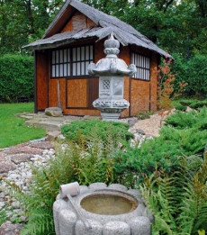Replika historické čajové chýše s lampou kasuga a s očistnou studánkou tsukubai.