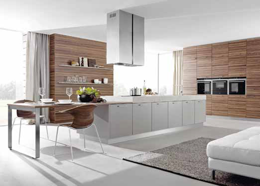 Letošní novinkou značky Schüller je kuchyň z řady NX602, ve které se kombinují jednobarevné plochy s dekory přírodního dřeva, které jsou použité i u nábytku v obývací části, orientační cena sestavy 490 000 Kč (NEXT TRADE STORE).