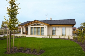 Dům jednoduchého obdélníkového tvaru  s nízkou sedlovou střechou a proskleným rizalitem  považují majitelé domu za optimální kompromis mezi starší zástavbou a moderní architekturou.