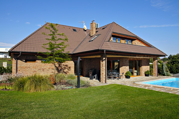 Dům je rozdělen na dva trakty – garáž  a společnou obývací část. Dominantní valbová střecha s velkým přesahem a režné zdivo charakterizují rukopis architekta Jiřího Houši.