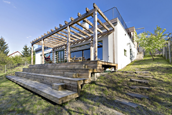 Vilka nenásilně využívá svah ve svůj prospěch. Stupňovitá dřevěná terasa je přirozeným pokračováním vnitřního prostoru domu.