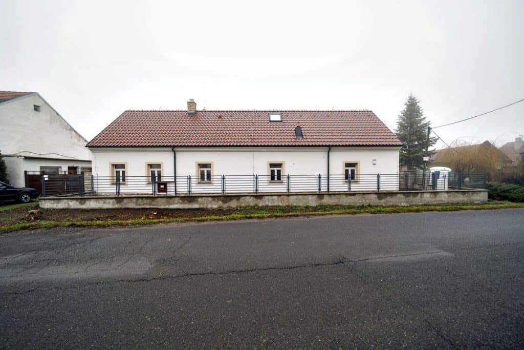 Štít zrekonstruované chalupy s malými okny se šambránami