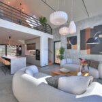 Design interiéru navrhlo studio Momenti Design. Hlavní obývací prostor má na stěnách šedou stěrku a na podlaze velkoformátovou dlažbu, neutrální základ doplňuje dřevo a prvky z černého kovu. Za kuchyňskou linkou se skrývá schodiště na galerii