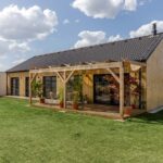 Dům má moderní kompaktní tvar bez velkých přesahů střechy. Modřínová fasáda bude přirozeně stárnout a stavba postupně ještě více splyne s krajinou