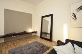 Stěnu za TV stolkem doplnil designér s nenápadnou, avšak díky struktuře zajímavou tapetou o ploše 240 x 240 cm.
