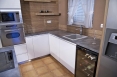 Pracovní deska v designu betonu a granitový dřez se barevně propojují.