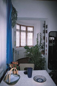Obývací pokoj s okny na venkovní verandu a s výhledy do zahrady.