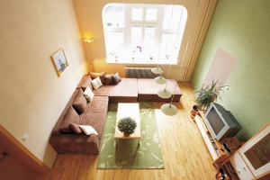 Designérka Lucie do obývacího pokoje zvolila závěsné osvětlení se čtyřmi lampami (MASSIVE). Bílé a zelenkavé mléčné sklo skvěle ladí s koncepcí celého prostoru.