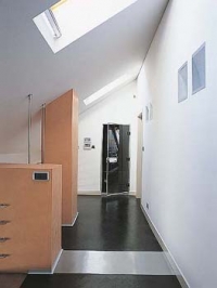 Galerie, na jejímž jednom konci je parní sauna se skleněnými dveřmi.