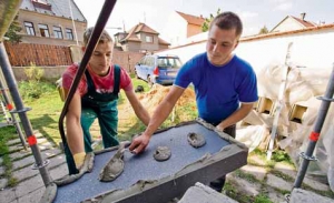 Aplikace lepicího tmelu na desky z šedého polystyrenu.