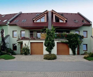 Jednotné dláždění žulovými „odseky“ a zrcadlové řešení zelených lemů dvojdomu prospělo.