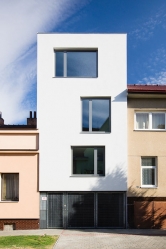 Při rekonstrukci řadového domu architekt Jan Kyzlink navrhl směrem do zahrady moderní prosklenou přístavbu propojenou s terasou a vodní plochou. Bydlení tak získalo úplně novou dimenzi. Směrem do ulice hledí střízlivá moderní architektura.