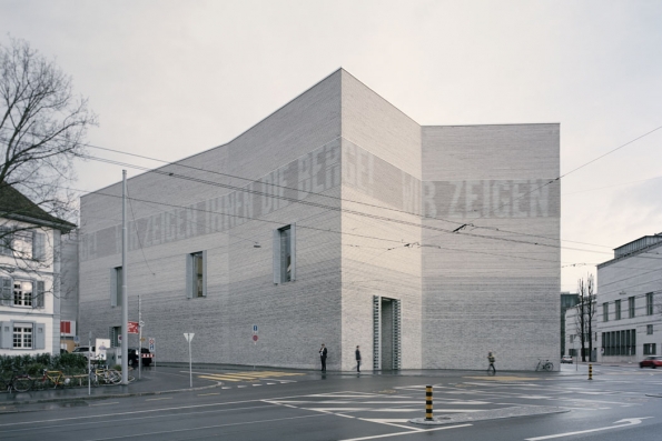 Brick Awards 2018: Hlavní cena + kategorie Sdílení společného prostoru: Dostavba Muzea umění, Basilej, Švýcarsko Architekt: Christ &amp; Gantenbein, Švýcarsko Nový objekt navazující na historickou budovu používá elementární základní tvary a stavební prvky. Ve fasádě ze světle šedých ražených cihel s plastickými horizontálními drážkami je intergrováno LED osvětlení, které vytváří na fasádě světelné „nápisy“ informující o právě probíhajících výstavách.