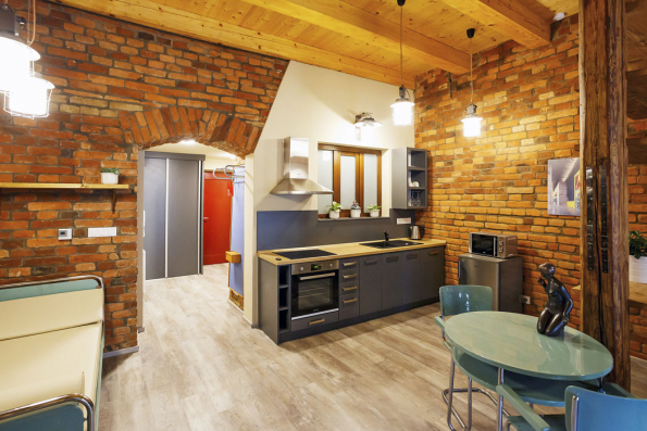 Loftový cihlový apartmán pro celou rodinu je rovněž vybaven originálním trubkovým nábytkem. Kombinace dřeva, kovu a cihel je velmi příjemná.