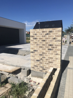 Ve venkovní části domu se provádí zděný plot z pálených cihel Terca. Základ byl proveden ze ztraceného bednění vylévaného betonem. Zmonolitněná konstrukce nese vyzdívaný plot a je podkladem pro nosnou část venkovní příjezdové brány vstupní branky (zdroj: Wienerberger )